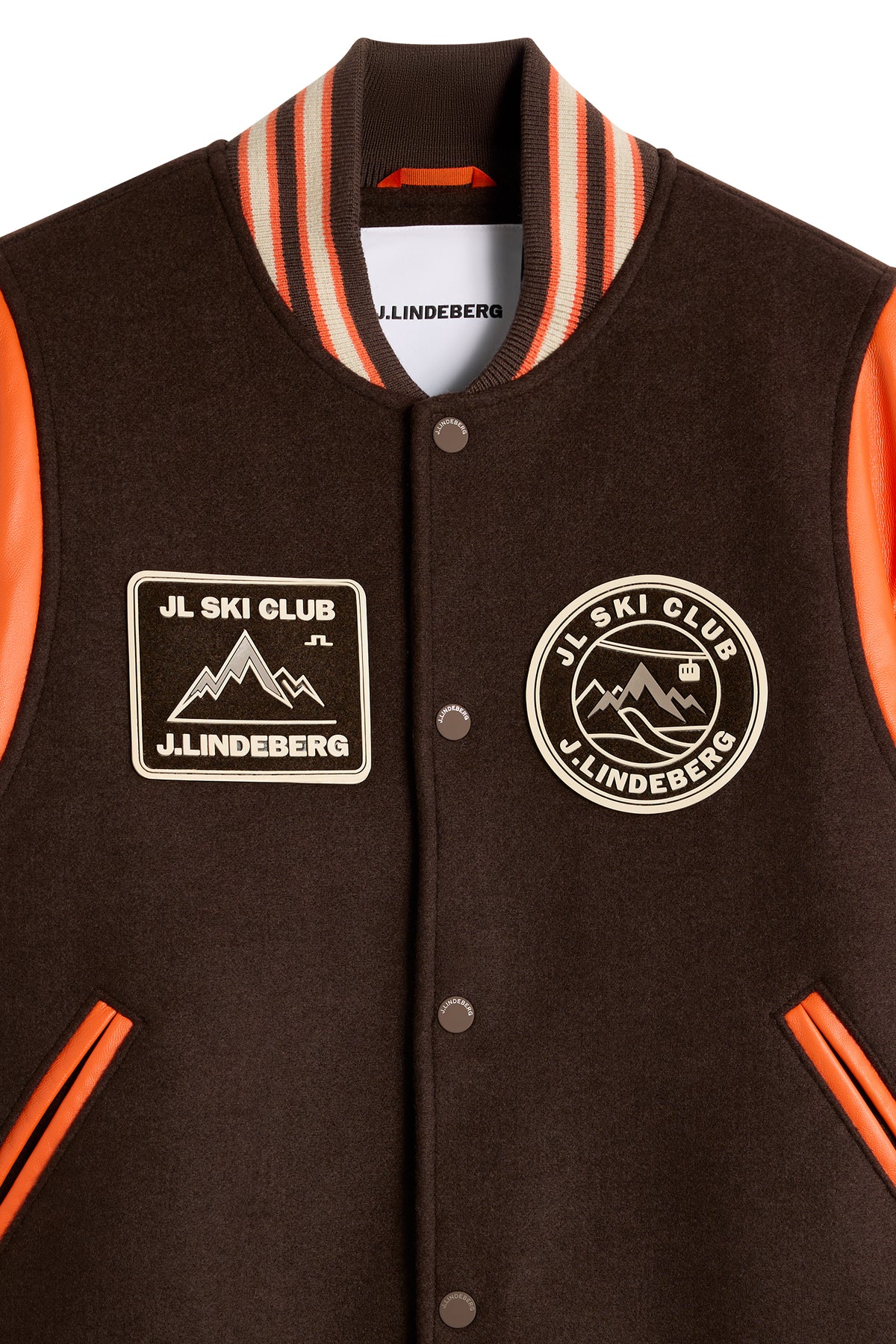 Close-up: Bobby Bomber Jacket in Seal Brown featuring JL Ski Club patches, snap buttons, and a striped ribbed collar.