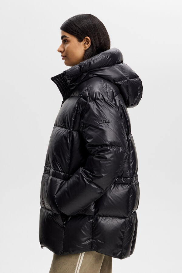 Side view of the Tranquil Down Jacket in black, featuring a hood and Bridge logo on the sleeve.