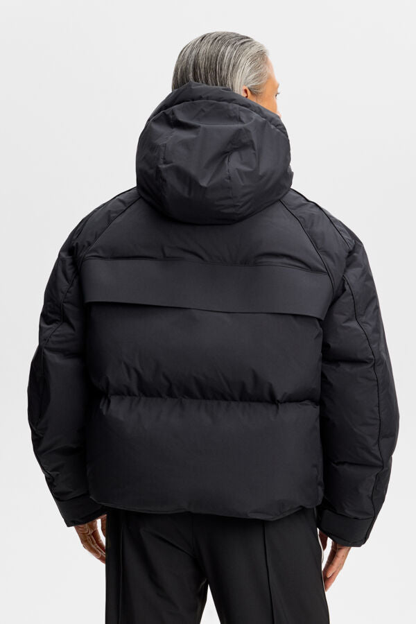 Back view of the Lea Down Jacket in black with a padded hood and horizontal quilting.