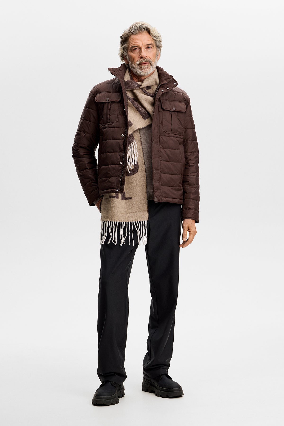 Model wearing the Bailey Light Padded Jacket in brown, front view with chest pockets, snap buttons, and a beige scarf