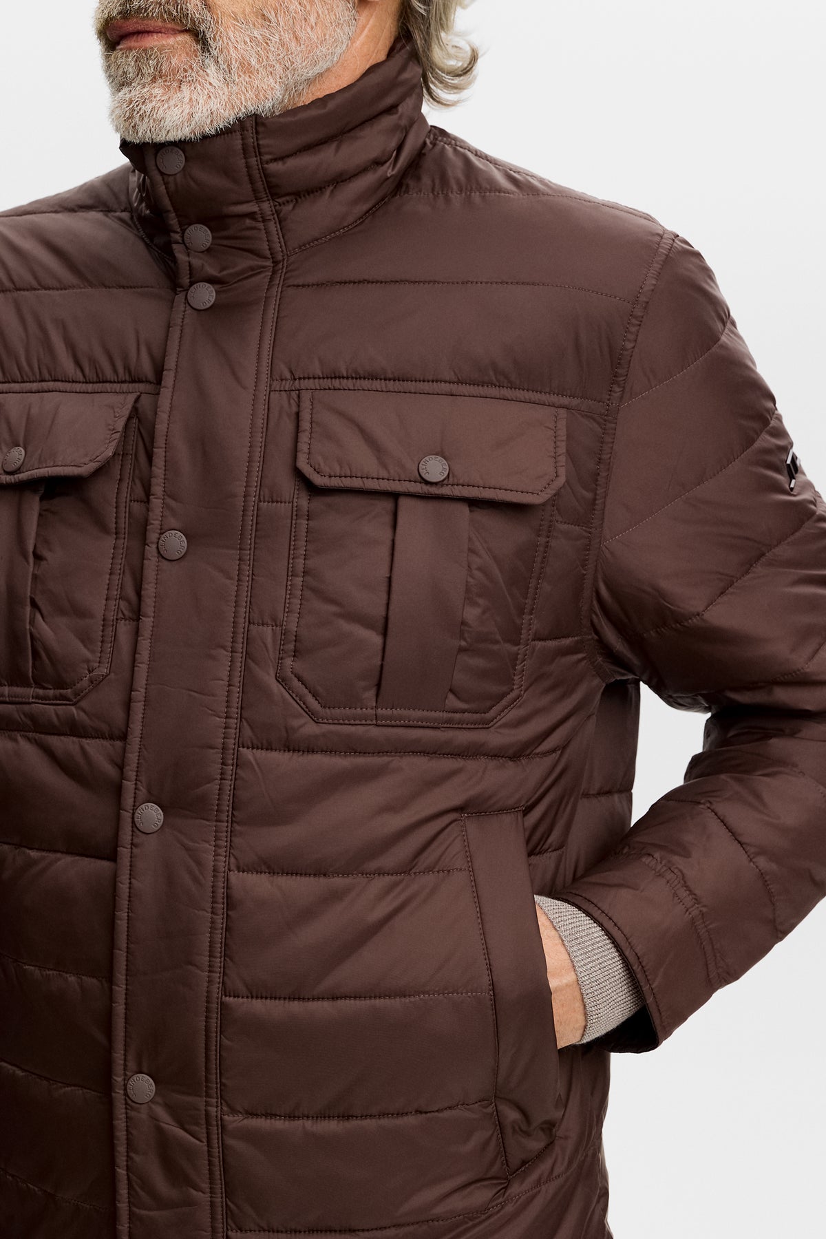 Close-up of the Bailey Light Padded Jacket in Seal Brown, showing snap chest pockets and quilted panels.