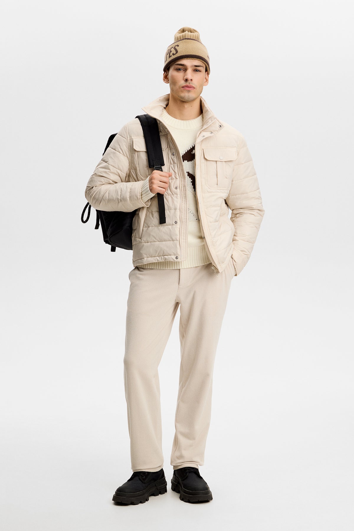 Model wearing the Bailey Light Padded Jacket in Moonbeam layered over a sweater in a studio setting.