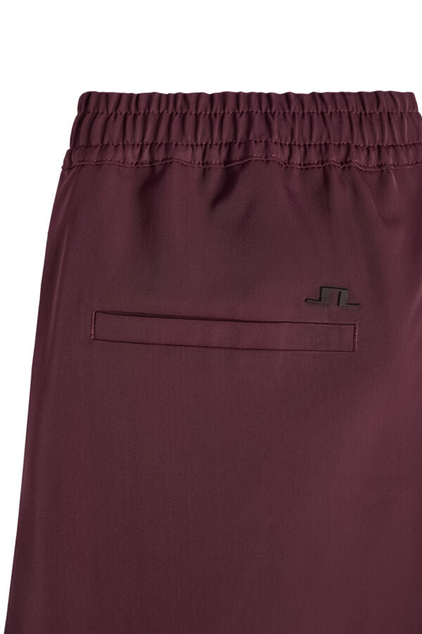 Close-up of the Anja Pant in Winetasting showing the elastic waistband, welt back pocket, and Bridge logo.