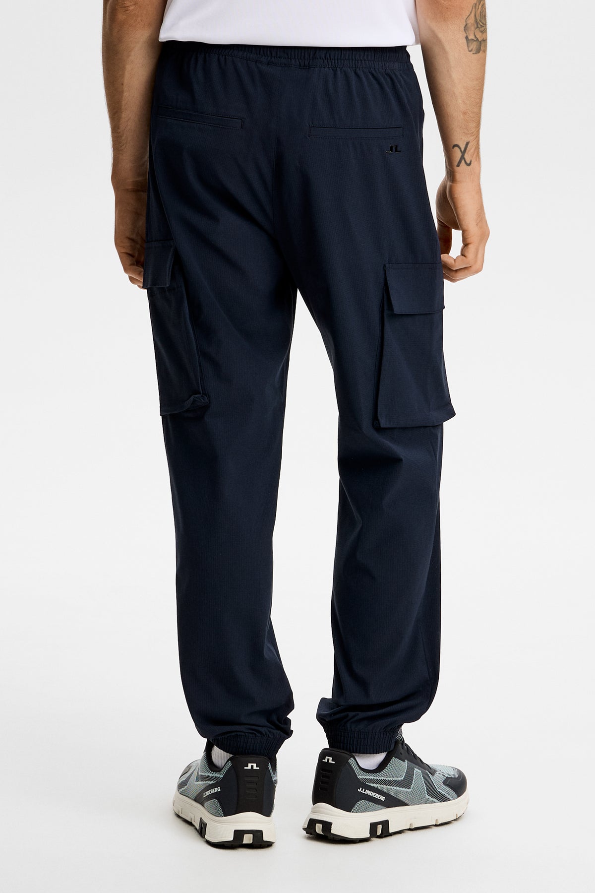 Harris Tech Pant in JL Navy, back view showing cargo pockets, back pockets, and Bridge logo.