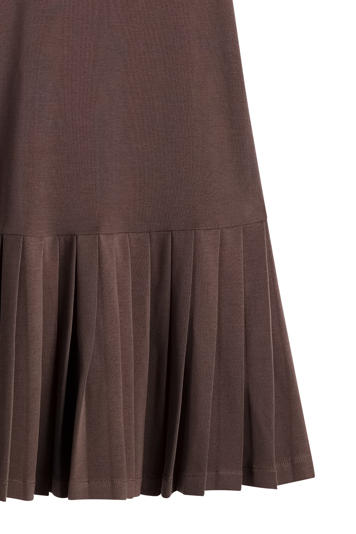 Close-up of the pleated skirt hem and textured piqué fabric on the Lacey Dress in Seal Brown.